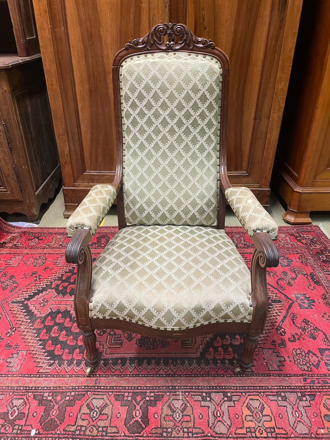 Fauteuil en bois foncé avec une garniture verte à motif losanges