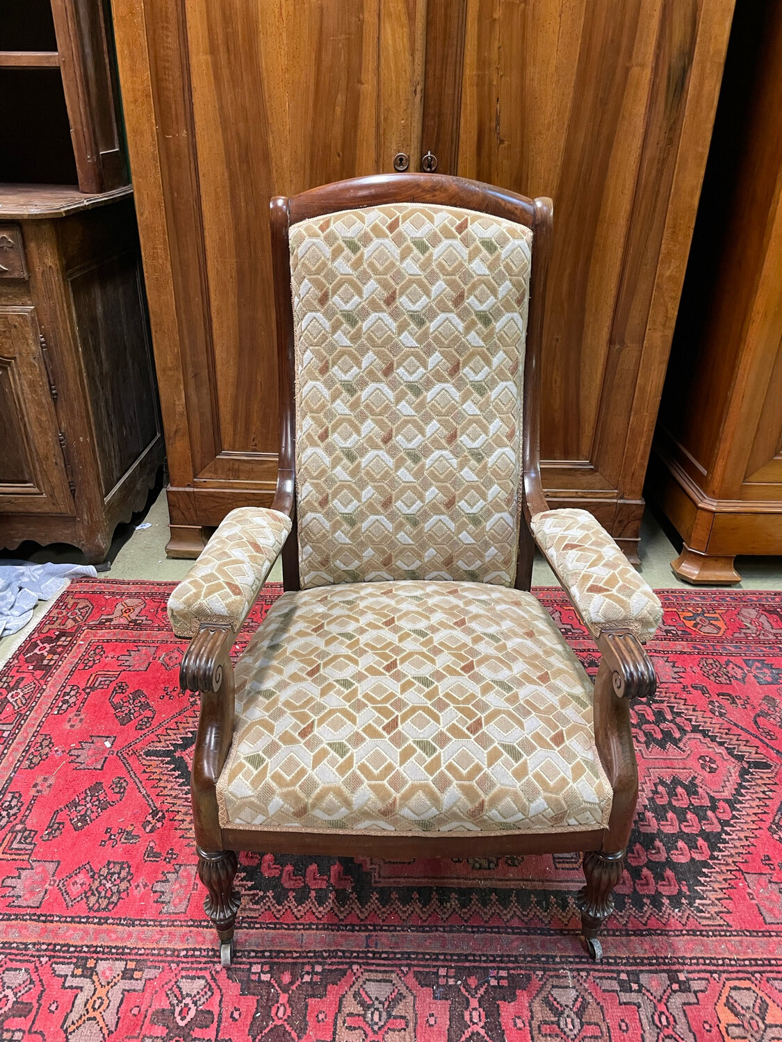 Fauteuil en bois avec garniture de tissu à décor géométrique, petites roulettes au pieds - H-108