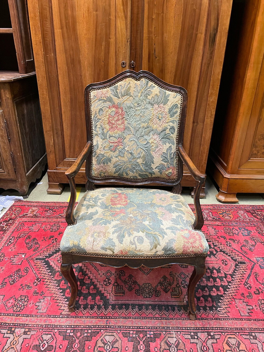 Fauteuil en bois mouluré. Dossier plat. Repose sur des pieds galbés terminés par des sabots - vers 1740
