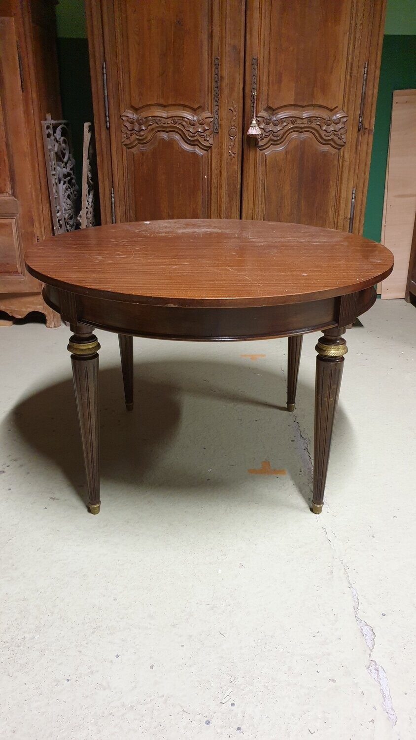 Table en bois teinté acajou et application de bronze doré, pouvant recevoir deux allonge de 48cm. Pieds cannelés, style Louis XVI - H-74cm D-111