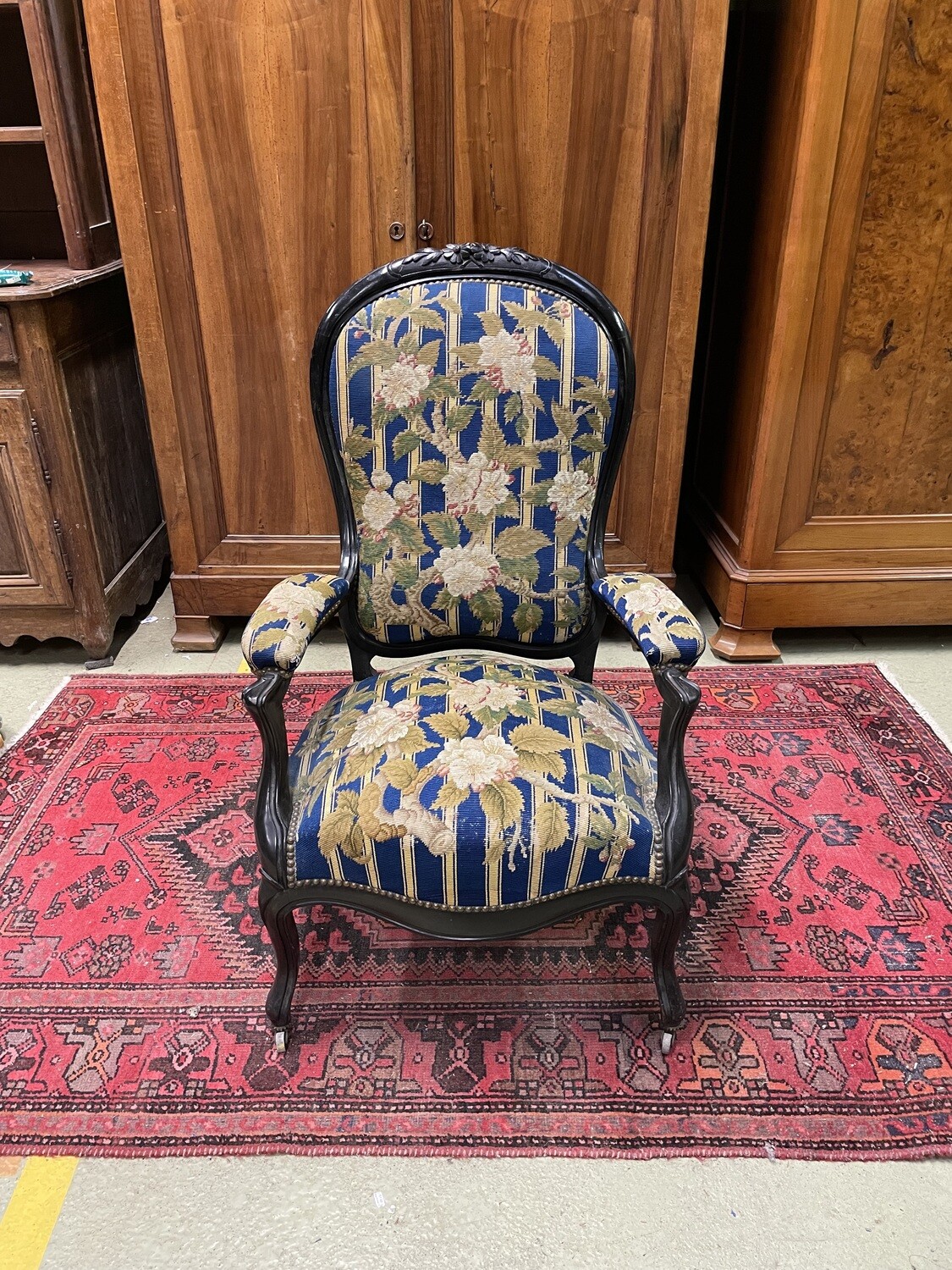 Fauteuil à dossier violoné en bois noirci, garniture tapisserie à sujet floral, époque NIII - H 110 cm