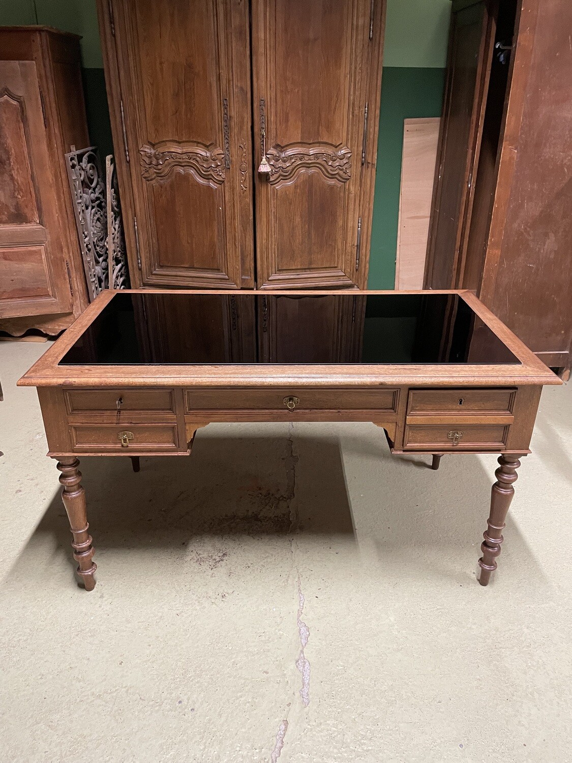 BUREAU en bois naturel, ouvrant à cinq tiroirs, le plateau dalle de verre fumé. Fin du XIXème siècle. 78 x 137 x 75 cm.