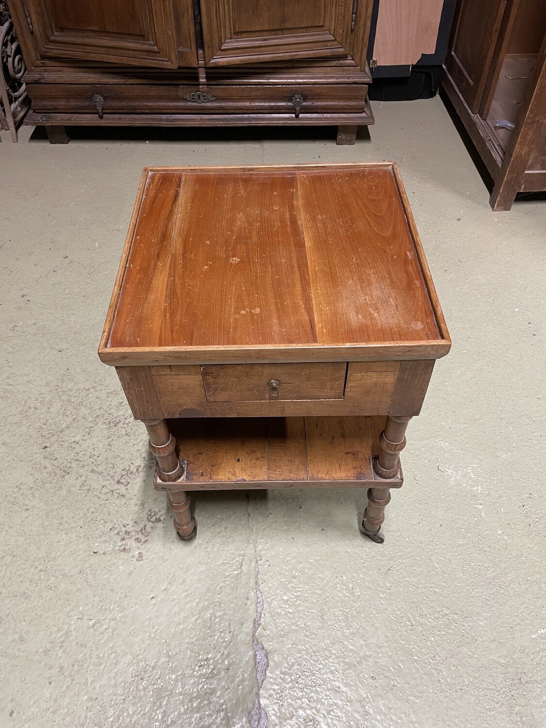 Table d'appoint de salon formant desserte en bois mouluré et sculpté, les montants à colonnes, tablette d'entrejambe et tiroir. Début du XIXème - H 73 cm L 50 P 50 cm