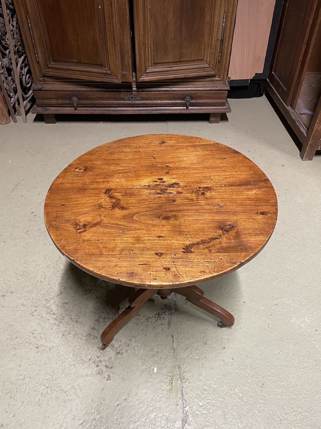 Guéridon circulaire en bois mouluré reposant sur 3 pieds à roulettes. H : 69 cm Diam. : 69 cm.