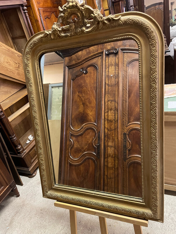 Miroir à rang de perle, cadre en stuc redoré et fronton coquille. H 114 cm