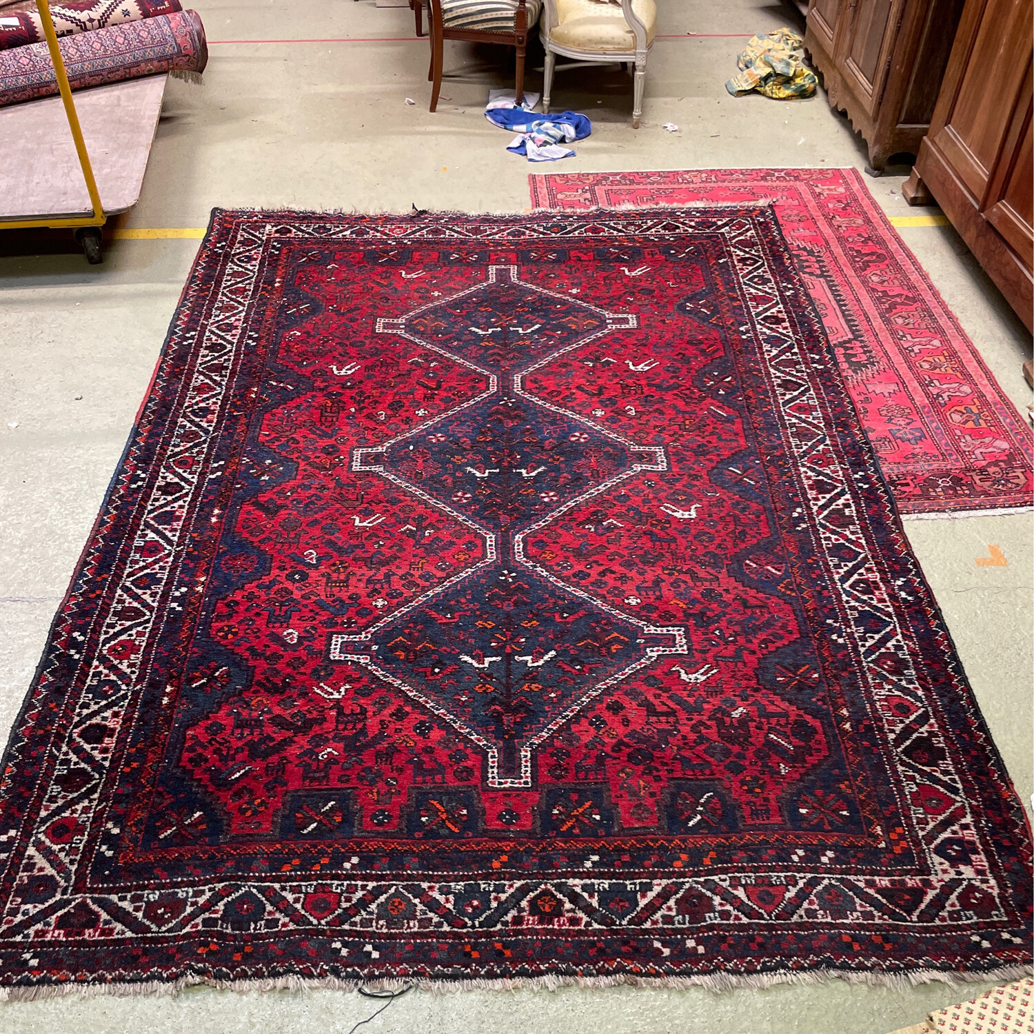 Grand tapis laine à fond rouge et à décor géométrique et animalier