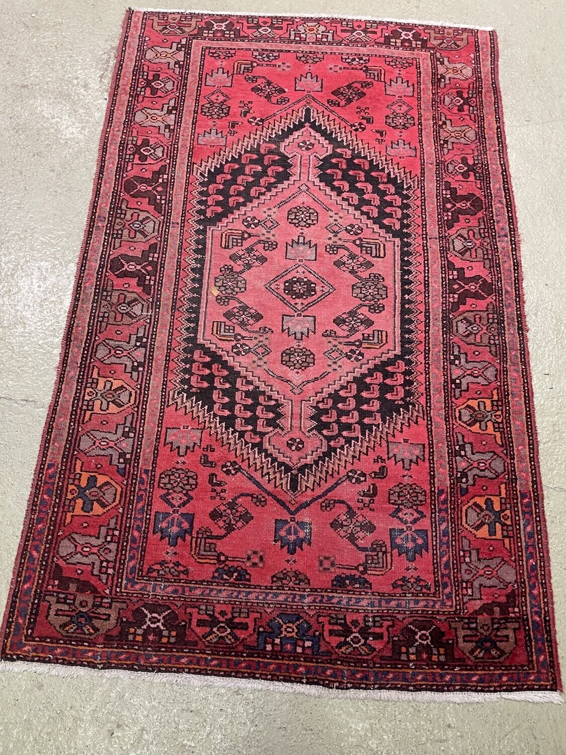 TAPIS d'Iran en laine à fond rouge à décor géométrique. 134 x 215 cm.