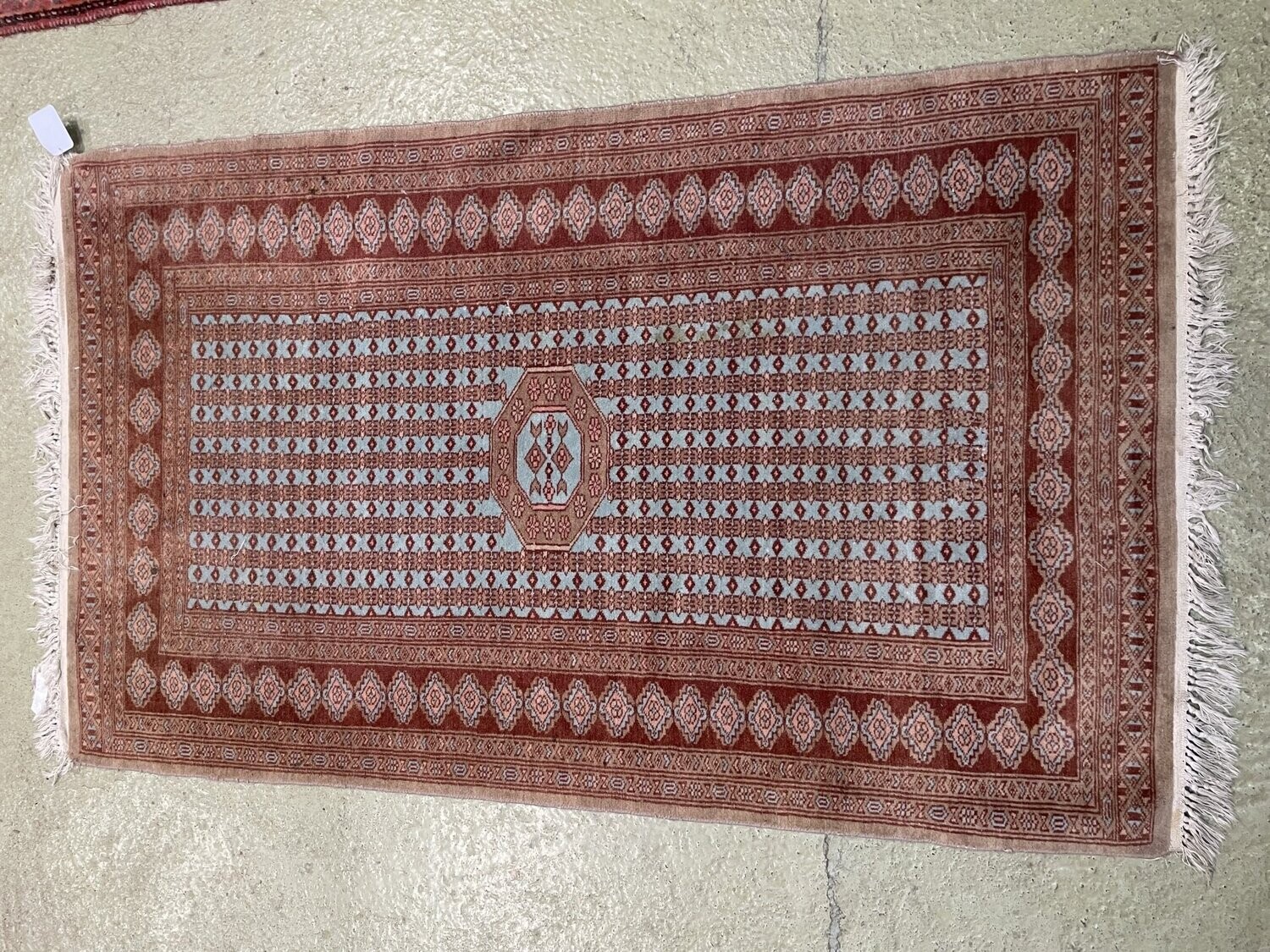 Tapis orient laine et coton, le champ à frise de cartouches bleu ciel encadré de multiple bordures, camaïeu rouge brique. 160 x 98 cm