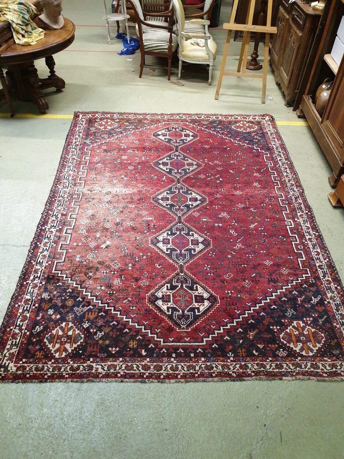 Grand tapis Chiraz en laine à décor de quatre figures géométriques dans des losanges sur fond rouge - 302 x 217 cm