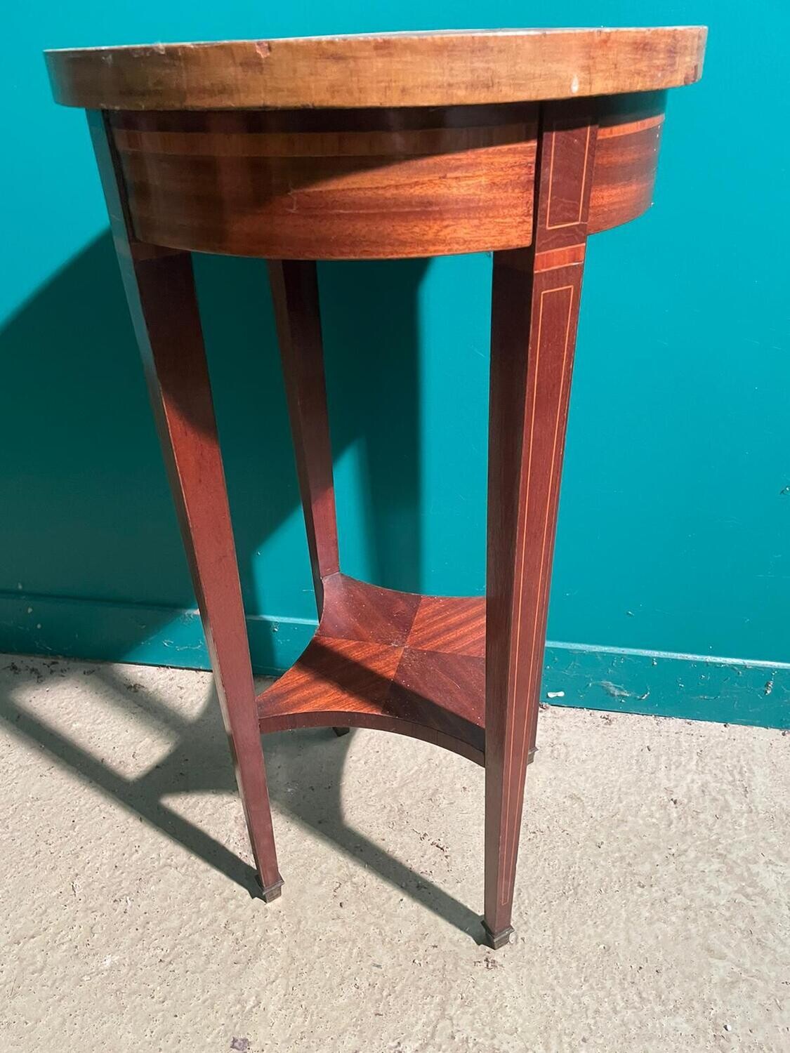 Table circulaire en bois de placage, plateau à décor rayonnant reposant sur quatre pieds gaines reliés par une tablette d’entrejambe légèrement échancrée, style Transition Haut. : 76 cm, diam. : 40 cm