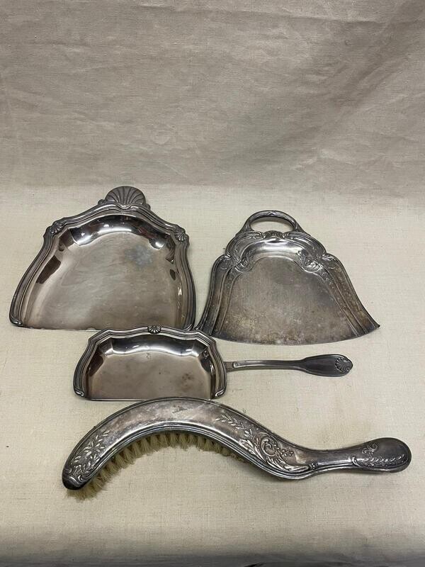 Trois ramasse miettes en métal argenté avec une brosse.