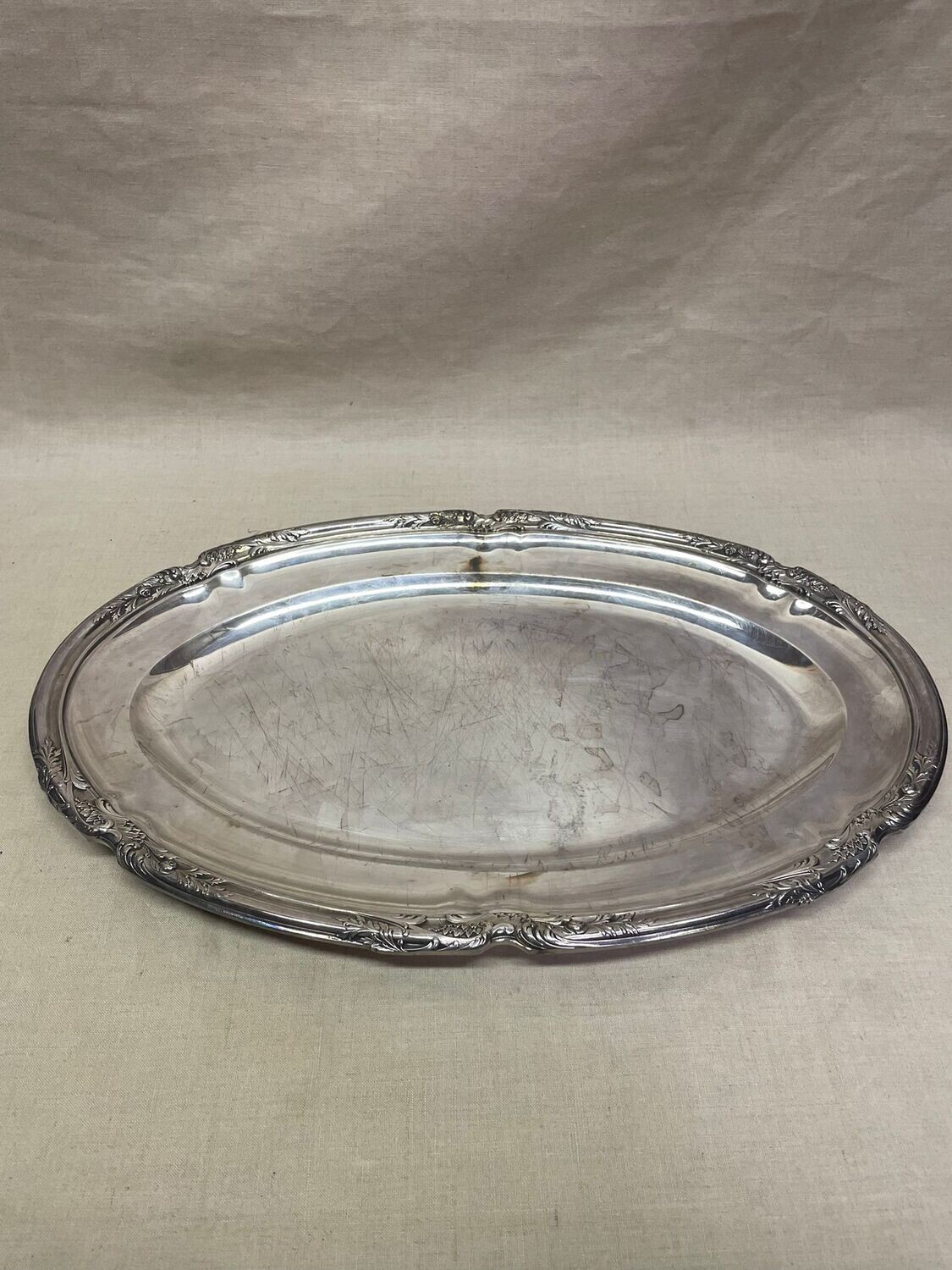 Boulanger : plat ovale en métal argenté, à décor de rinceaux et de fleurs. 41x27 cm.