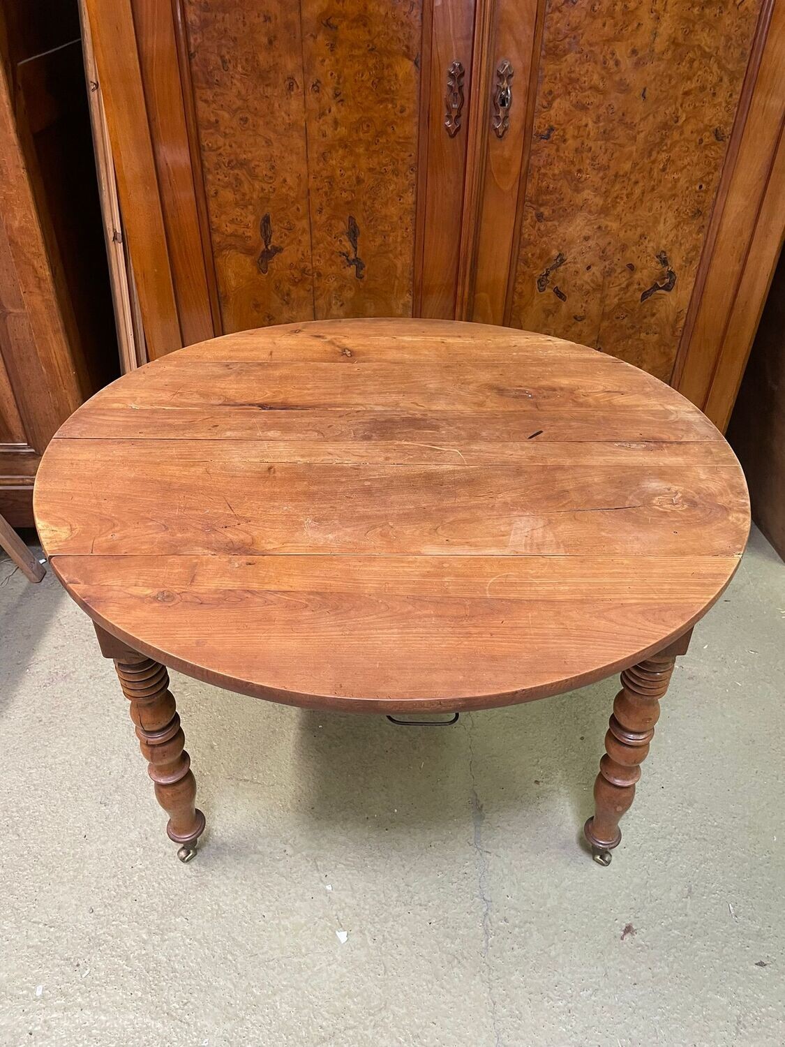 Table à abattant en noyer , pieds tournés reposan sur des roulettesen laiton avec une allonge - 72 cm