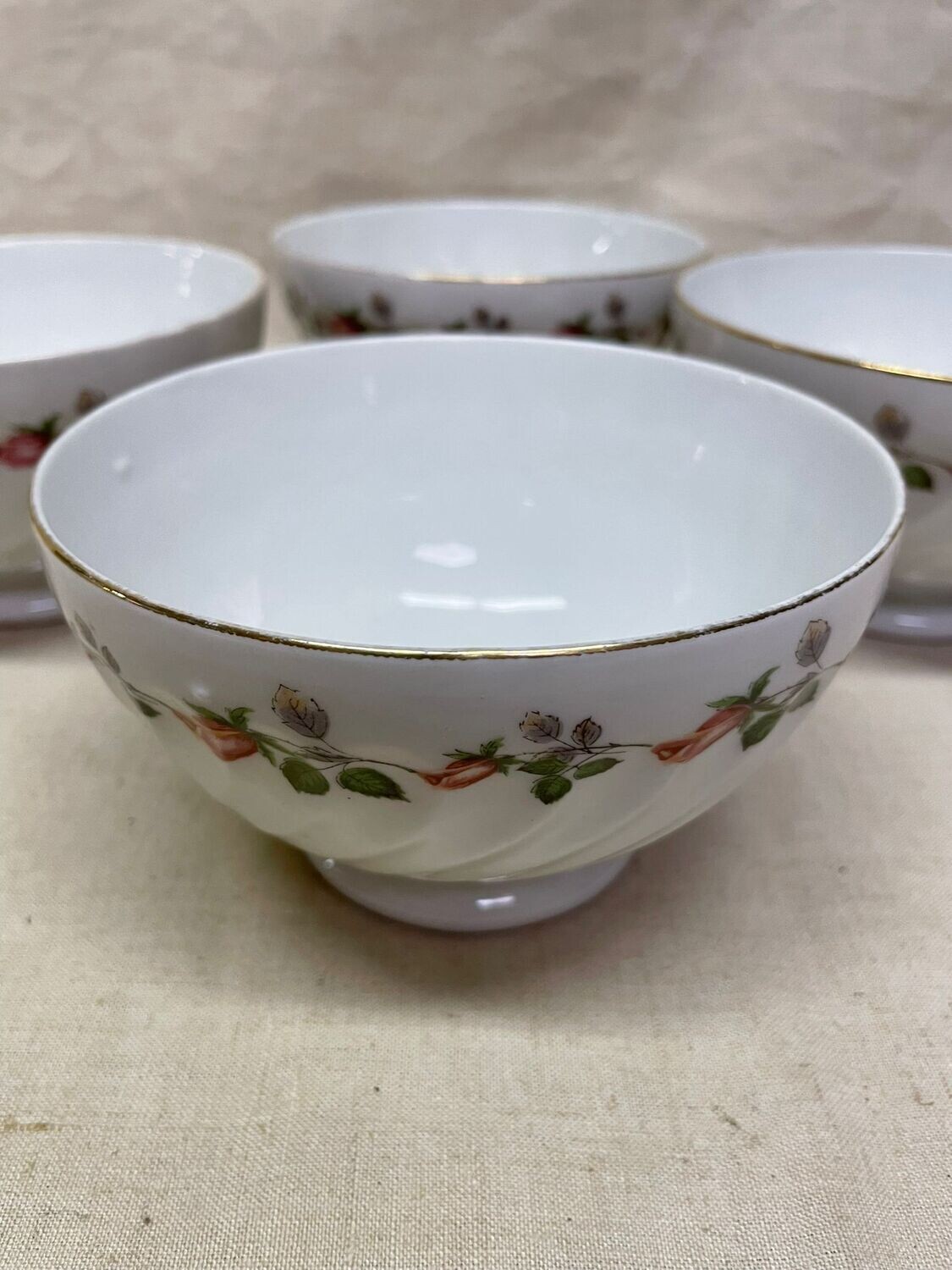 Quatre bols GIEN , en porcelaine blanche, filet doré et décor floral