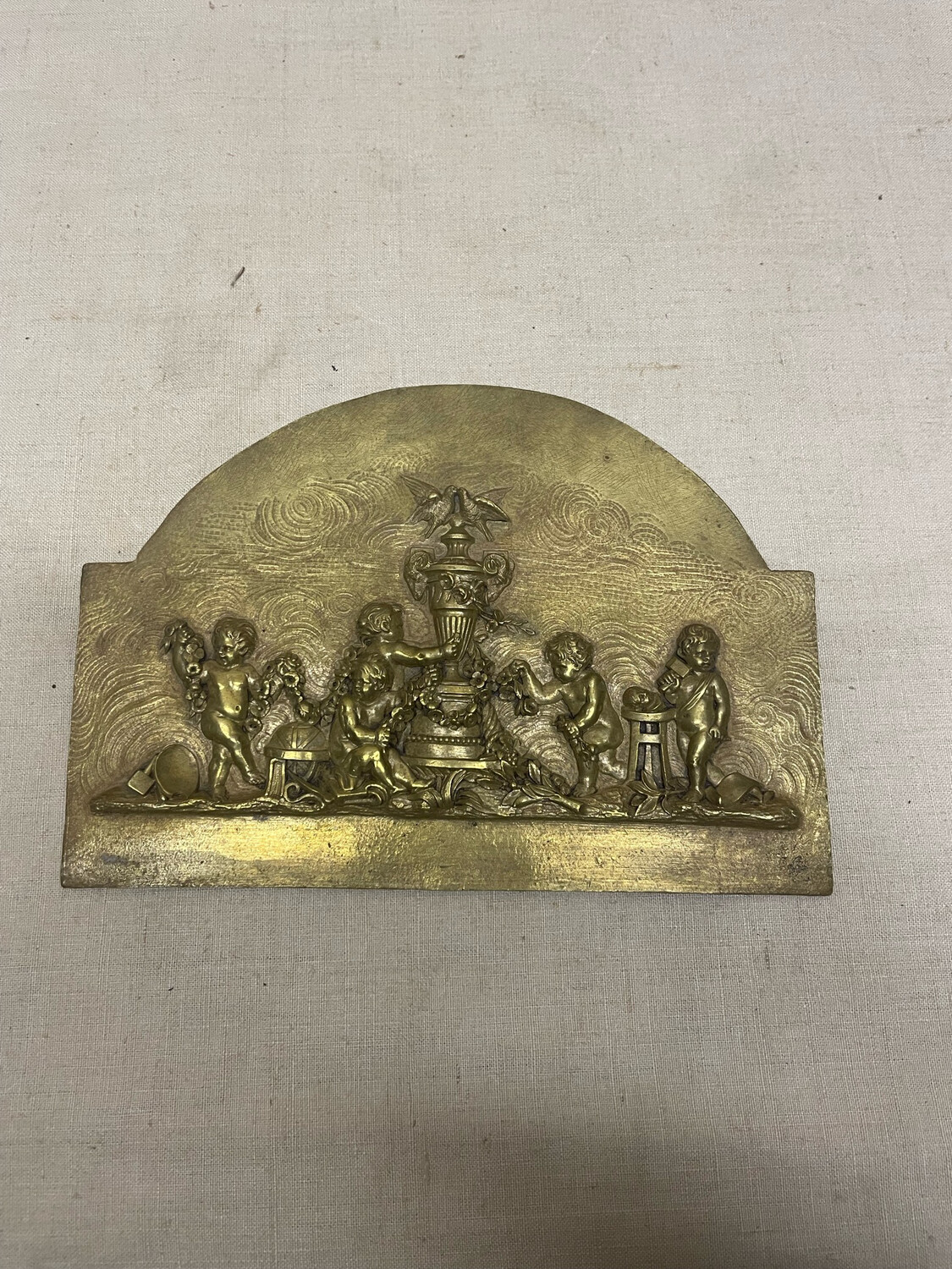 Petite plaque en bronze représentant des putti, entourant un vase. 13x18.5
cm.