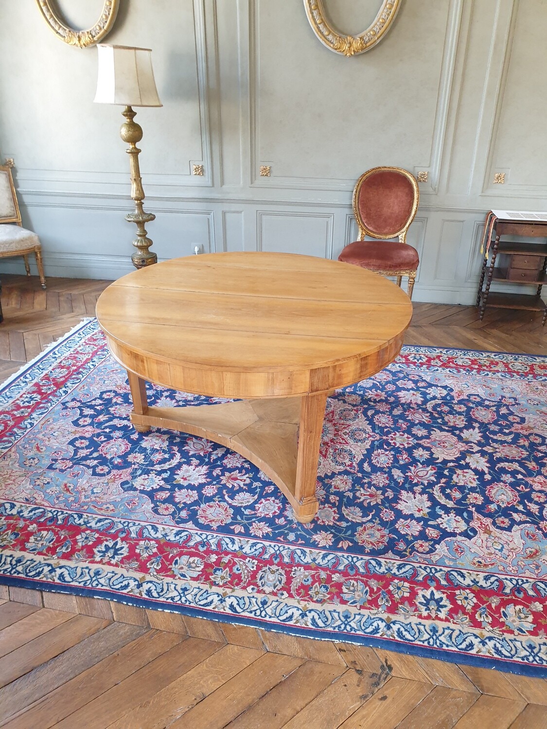 Table ronde reposant sur trois pieds réunis sur la base - H 72 x D 126 cm