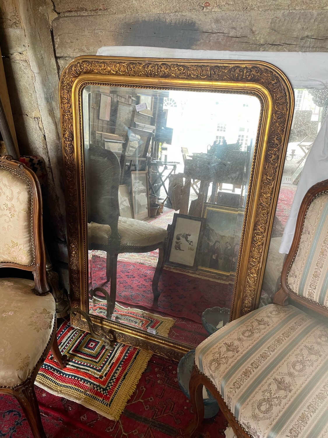 Miroir en bois stuqué et doré à front cintré à décor de rinceaux 
feuillagé