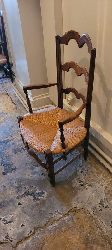 PAIRE DE FAUTEUILS "bonne femme" en bois naturel mouluré et sculpté, assises paillées. XIXème siècle. 92 x 48 cm.