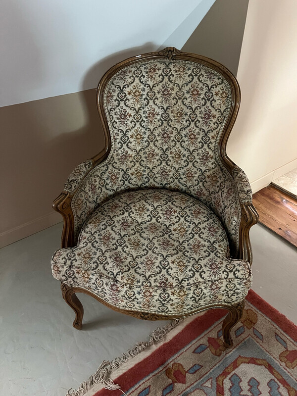 Fauteuil en bois fruitier mouluré et sculpte, garniture de tissu crème à décor floral, XVIIIème