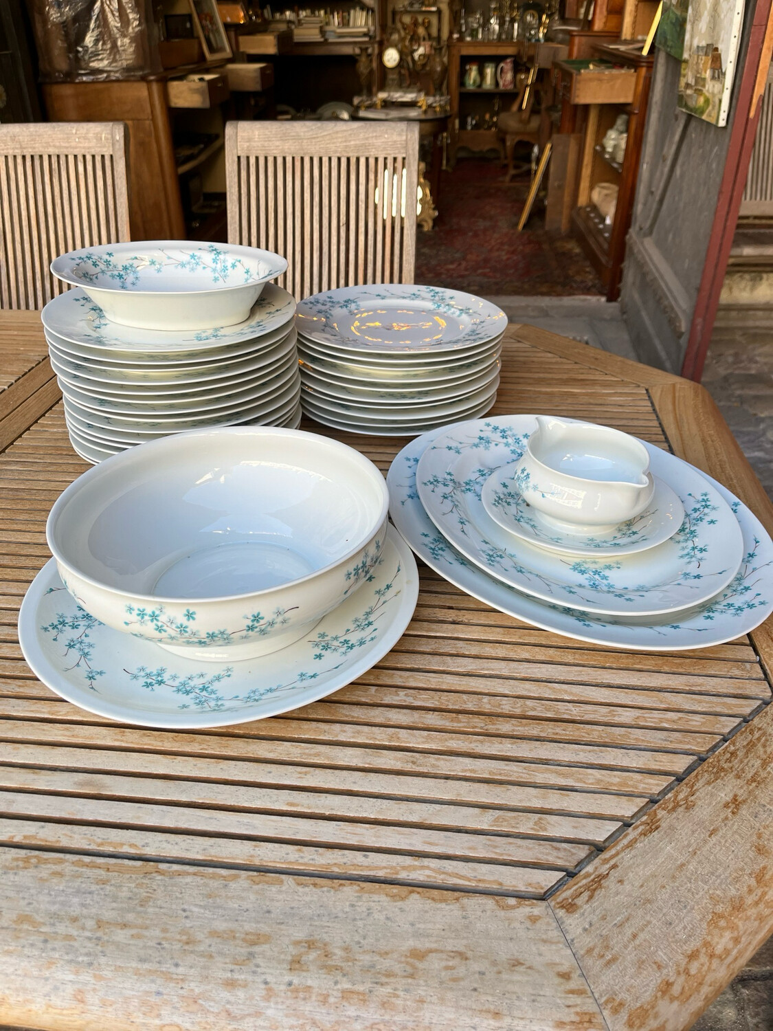 LIMOGES, service de table en porcelaine blanche à décor floral bleu comprenant 24 grandes assiettes, 2 plats oblongs, 1 plat circulaire, 1 saladier, 1 saucière et 1 jatte creuse.