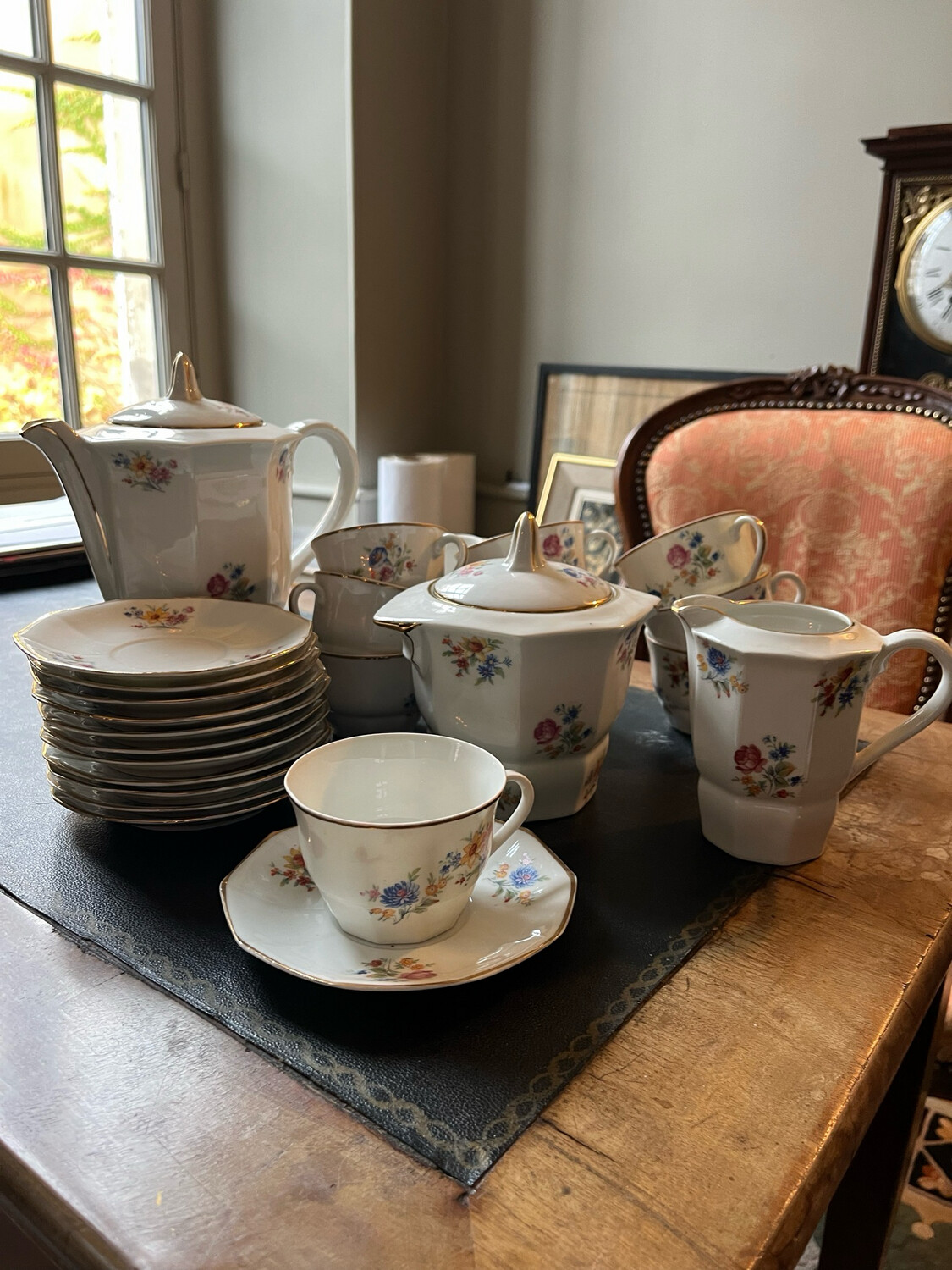 Service à café en porcelaine à décor floral, comprenant 12 tasses, un sucrier, une cafetière et pot à lait.