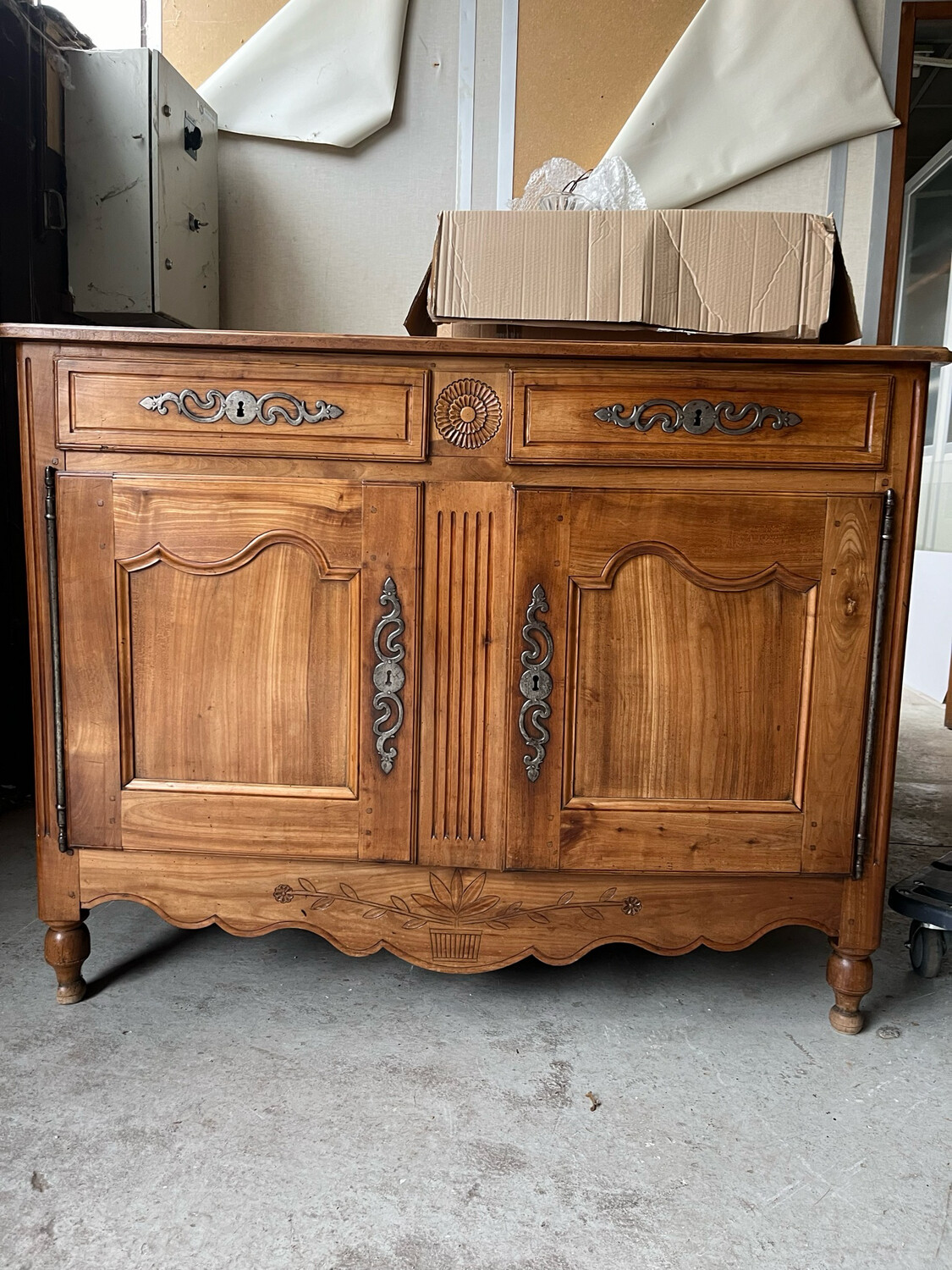 Buffet en bois fruitier à décor sculpté de rosace et panier fleuri ouvrant à deux portes moulurées avec faux dormant, XIX ème. 100x130x60 cm