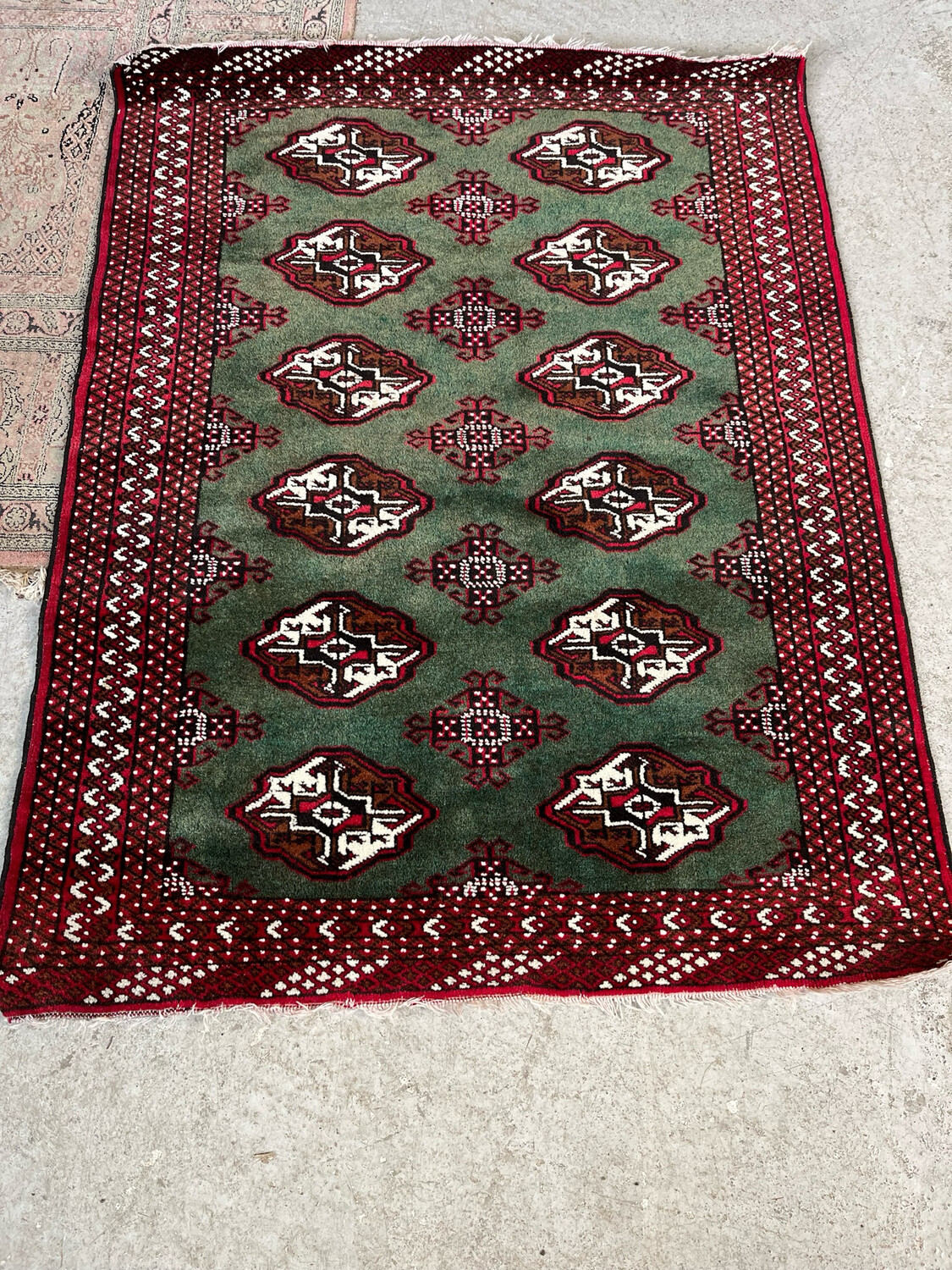 BOUKARA. Tapis en laine à décor de médaillons sur fond vert - 103 x 133 cm