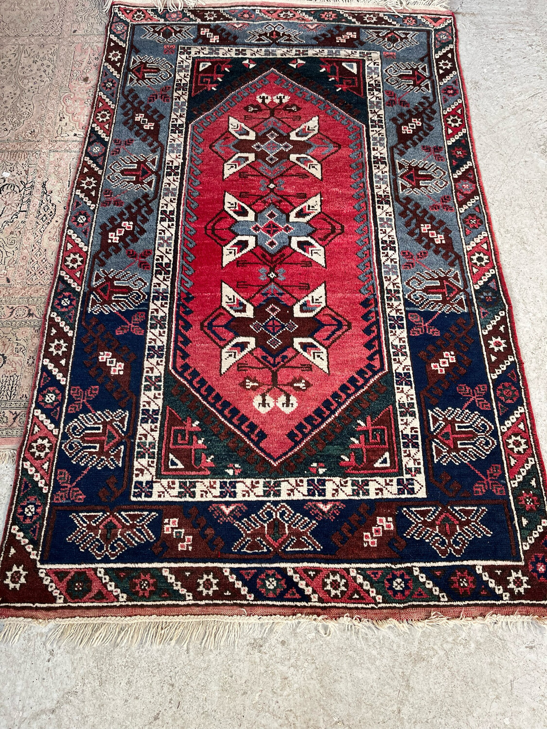 Afrique de nord : Tapis berbère de laine à motifs sur fond rouge. 200 x 122 cm