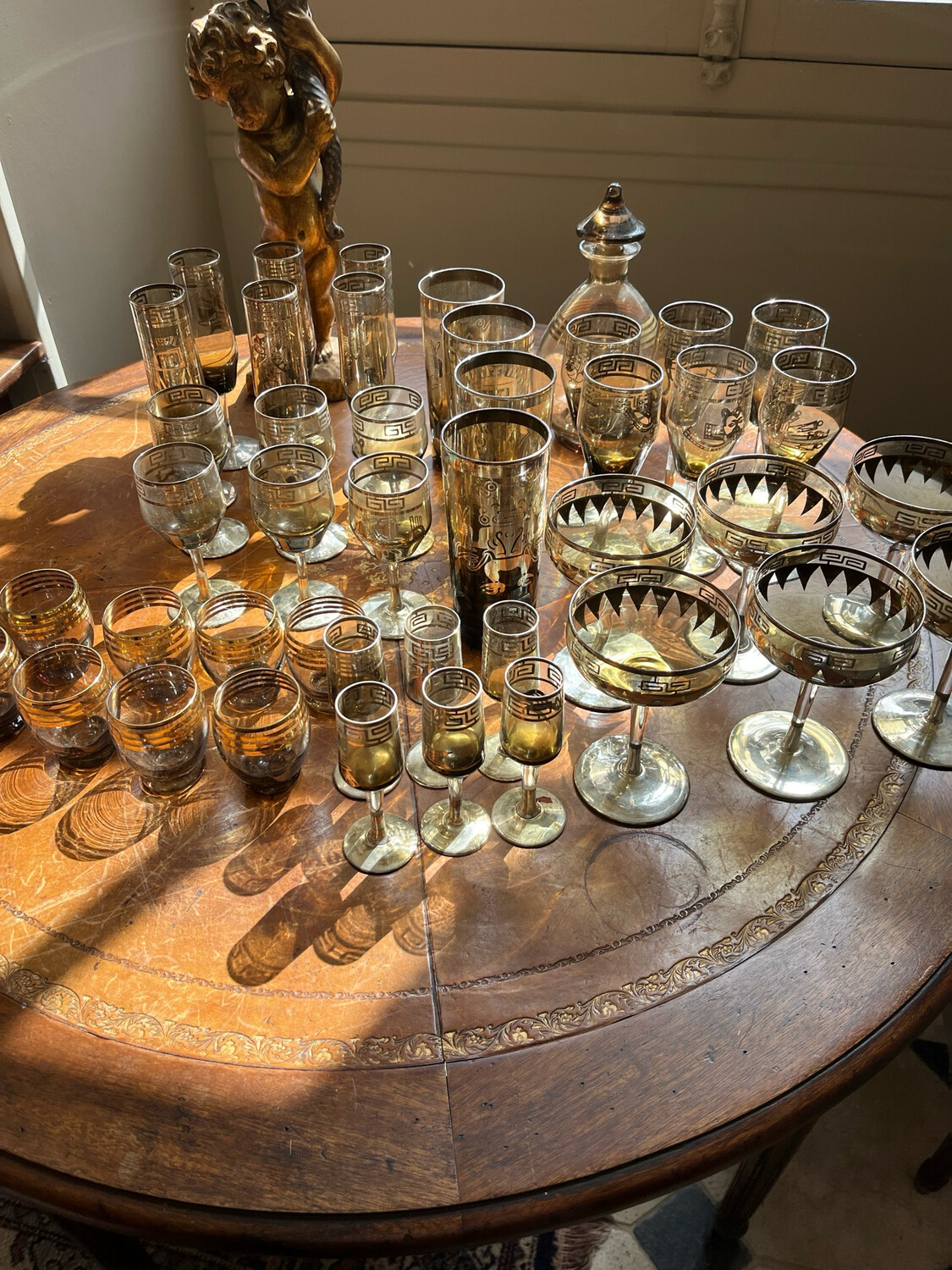 Service de verre en verre teinté à décor chromé, Précolombien comprenant : carafe, verre à orangeade, flûte de champagne, verre à porto, verre à liqueur, coupe de champagne, verre à vin