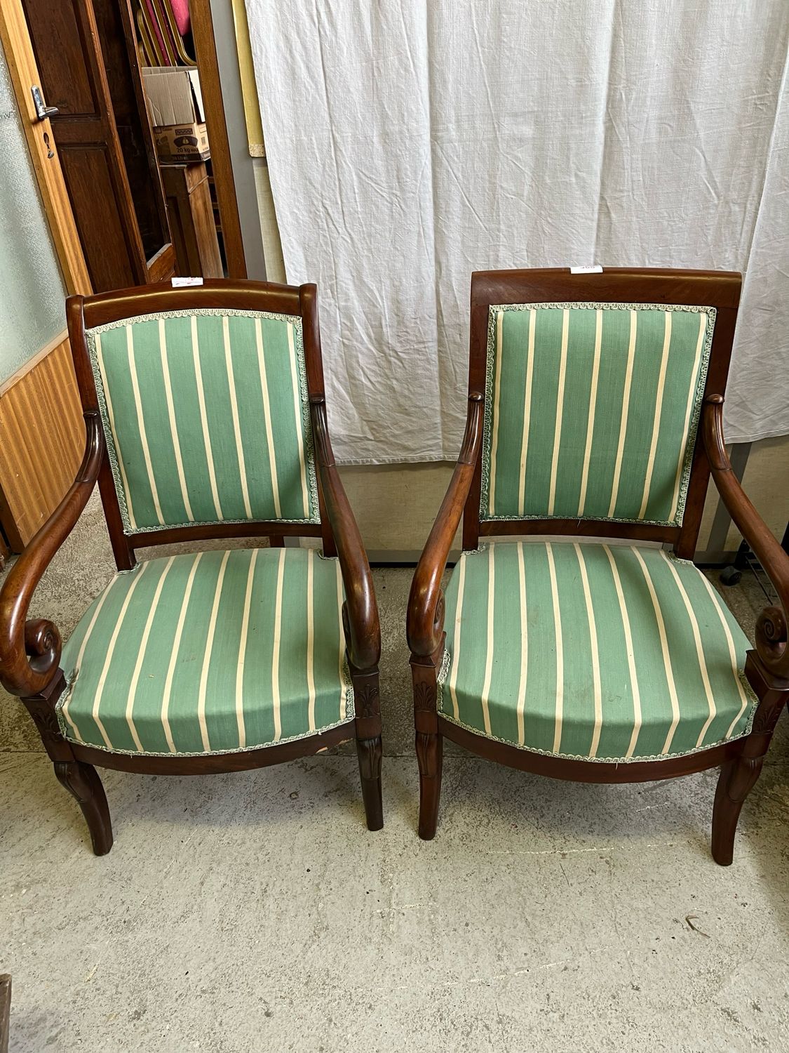 Paire de fauteuils en acajou accotoirs en crosse, piétement antérieur dit en jarret d’animaux et postérieur sabre.