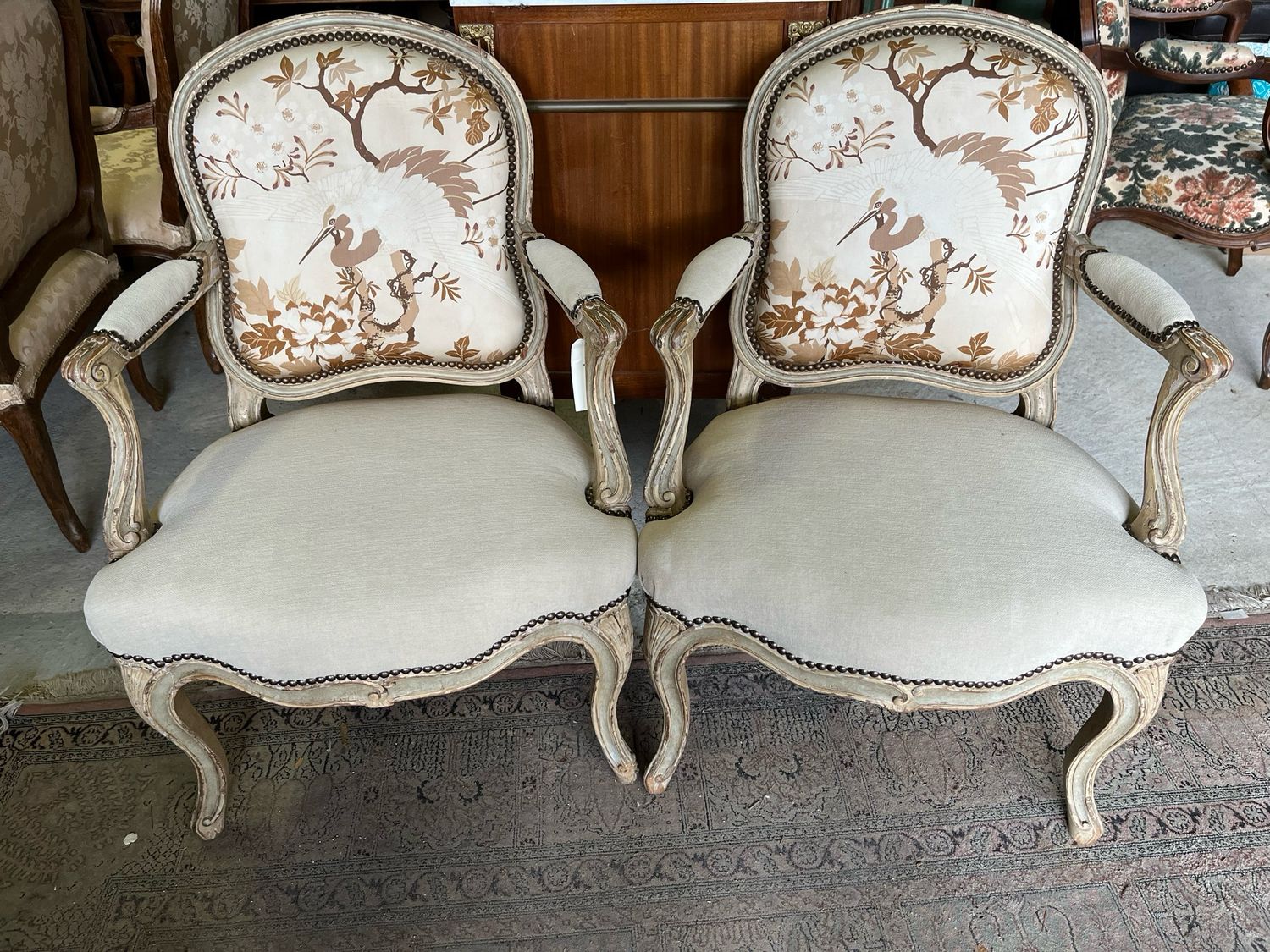 Paire de fauteuils style Louis XV, avec une cigogne perchée sur son arbre.