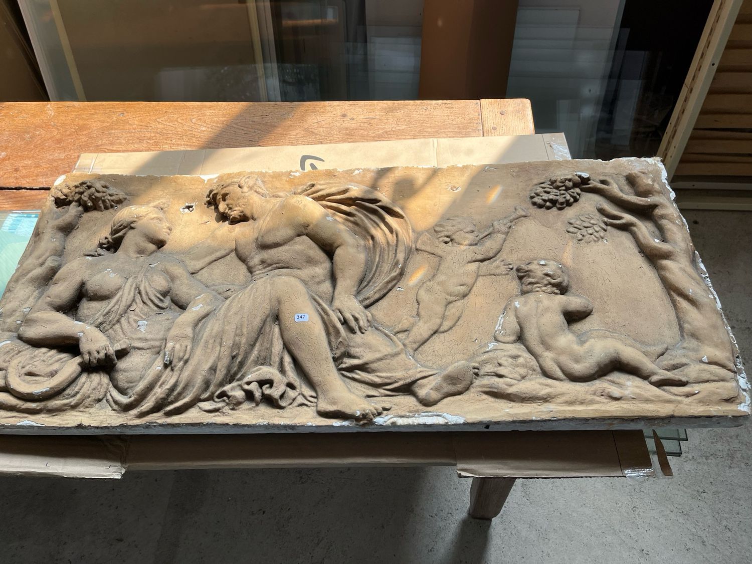 Bas-relief en plâtre patiné de forme rectangulaire à décor d’une scène à l’antique - 46 x 102 cm. Usure et petits accidents.