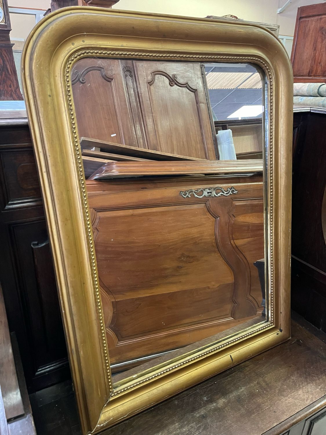 Glace rectangulaire en bois et stuc doré à décor d’une frise de rang de perle - 99 x 75 cm Usures et manques