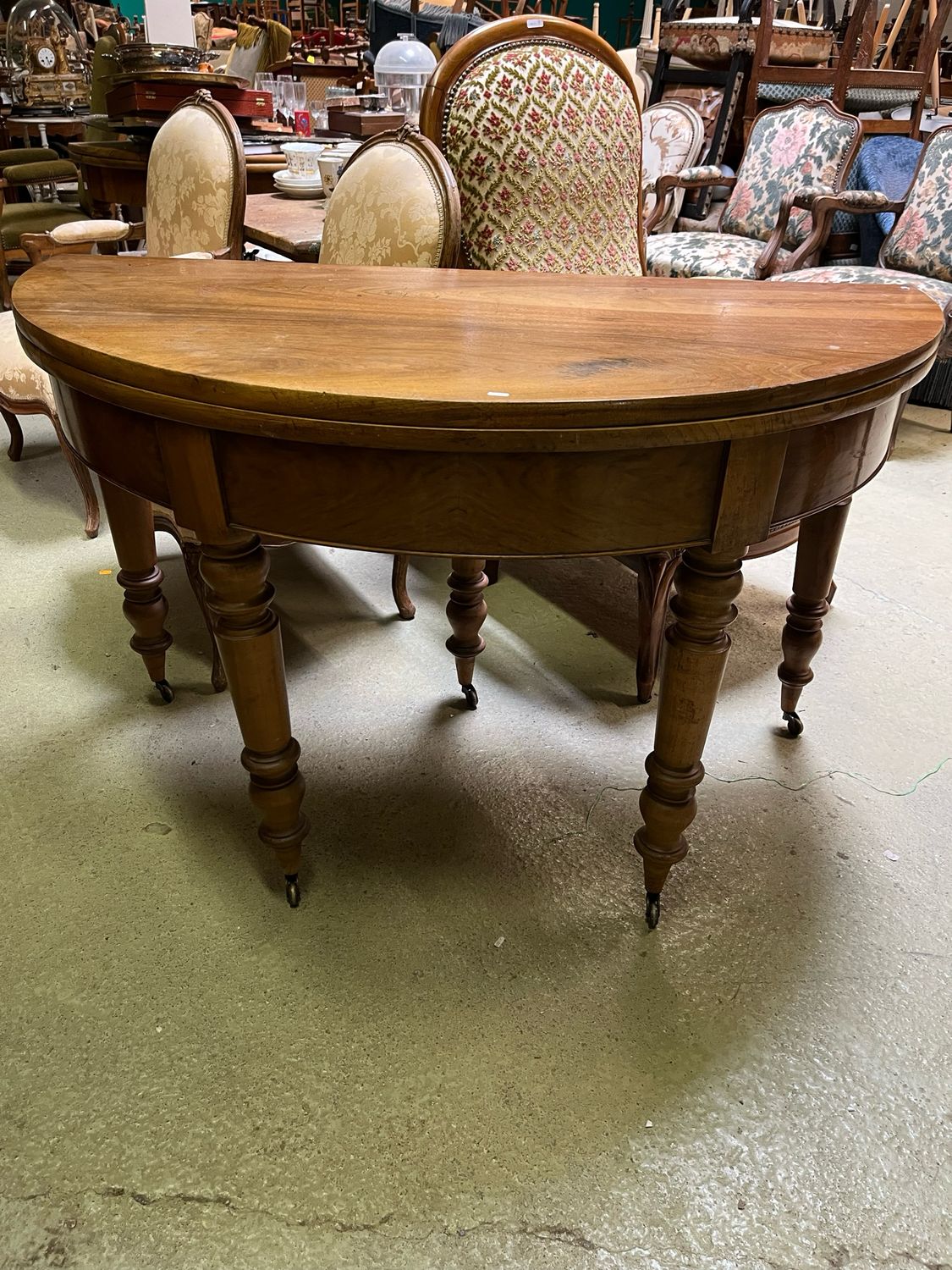 Table ronde formant console en noyer clair reposant sur cinq pieds tournés terminés par des roulettes, XIX - H 77,5 cm