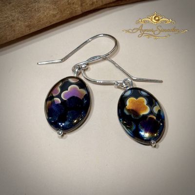 Handgemaakte zilveren oorbellen met druppelvormige glasparels en bloemmotief