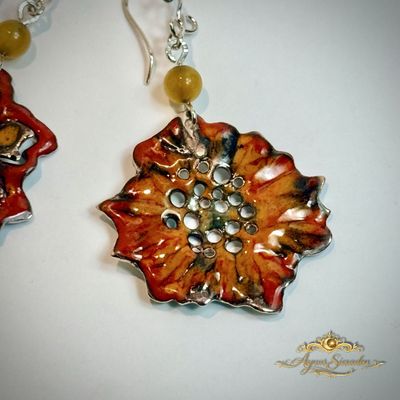 Detail van handgemaakte emaille vuurlelie oorbel met bloed carneool en zilver