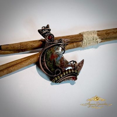     Handgemaakte koperen hanger met petrified wood steen op houten achtergrond
