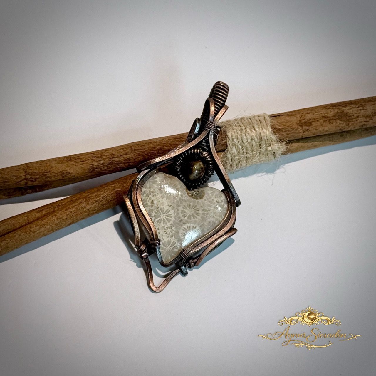     Handgemaakte fossil coral hanger van koper op houten achtergrond