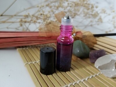 Gradient blue pink bottle with gold label containing anointing oil open to show roller