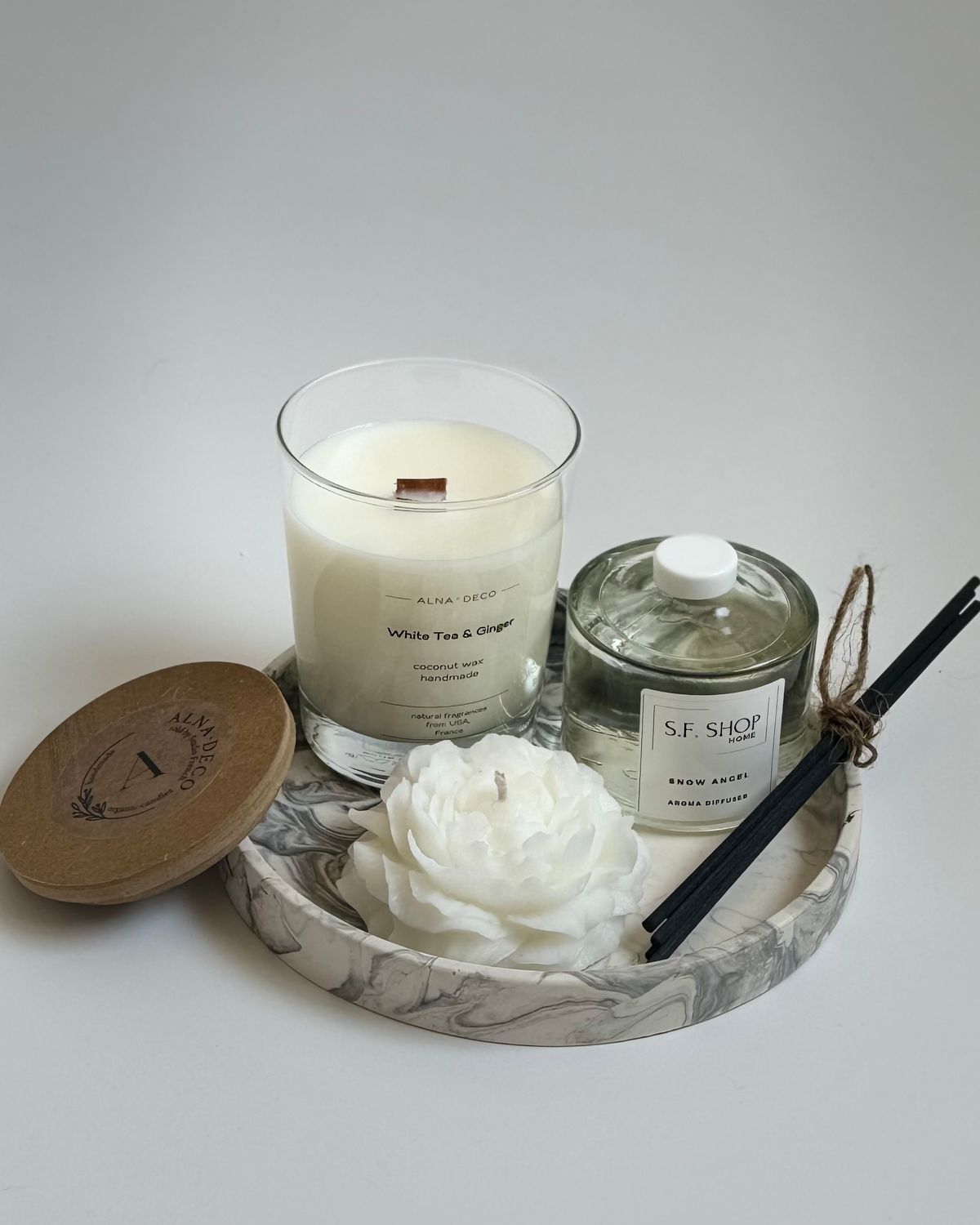 Aroma box with a candle in the shape of a peony on a round stand