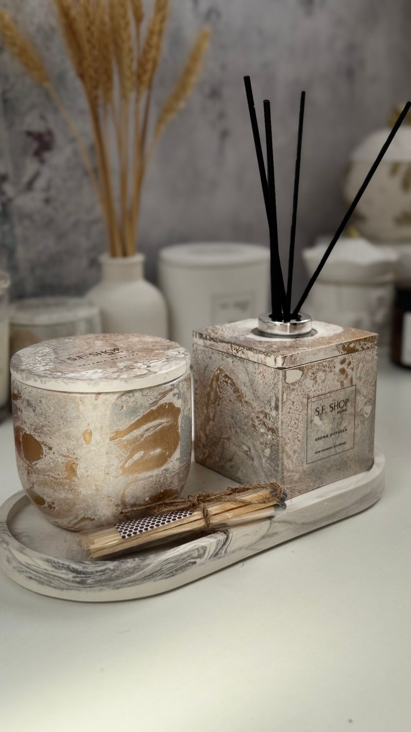 Interior set with a candle in a gypsum candlestick and a diffuser on a stand and a cube frame