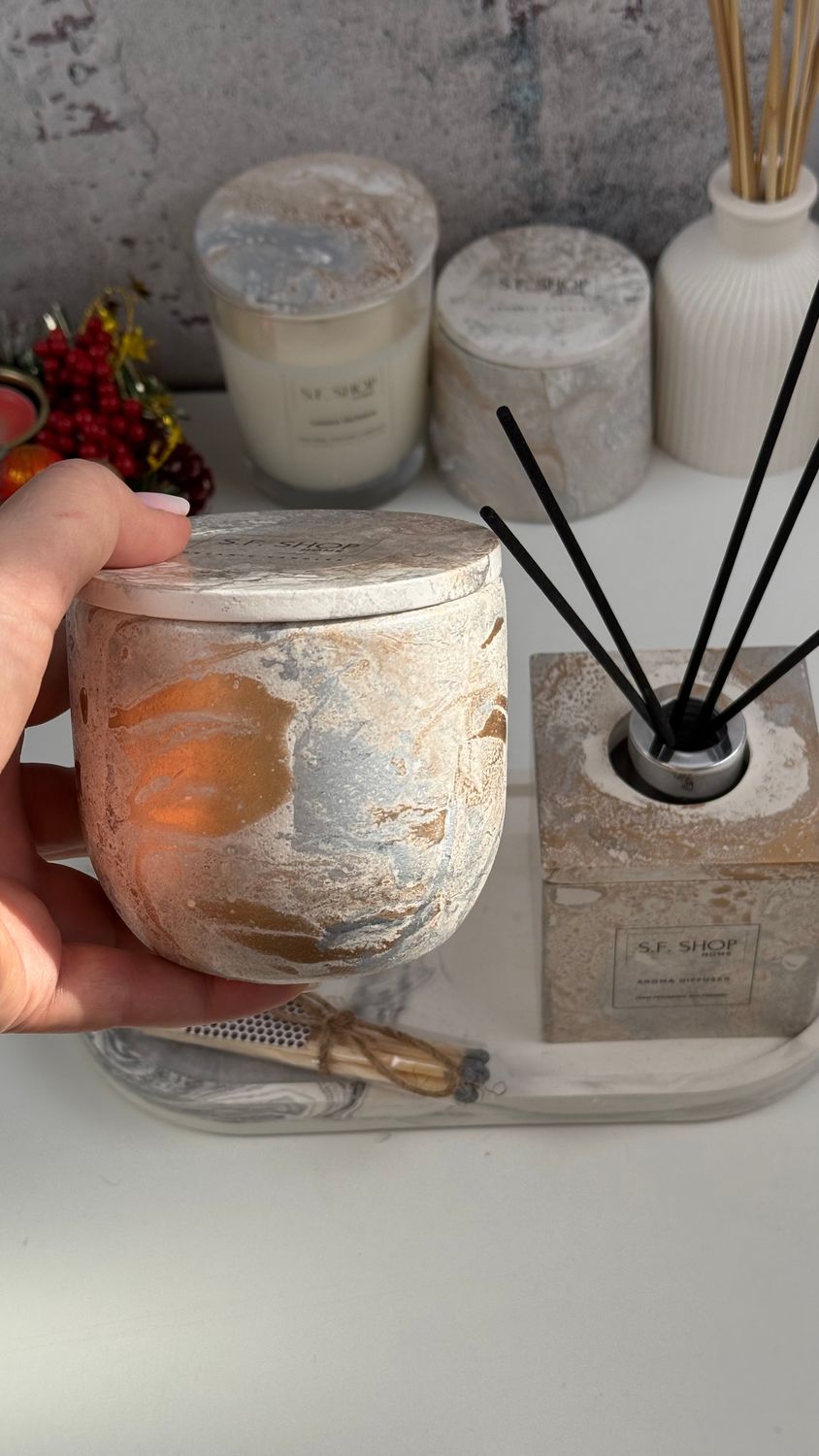 Interior set with a candle in a gypsum candlestick and a diffuser on a stand and a cube frame