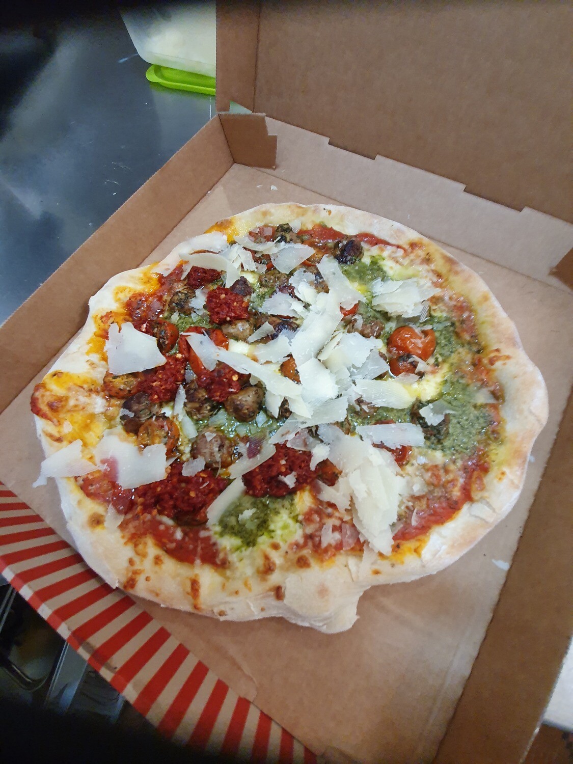 Pizza Pizitaneia: sauce tomate mozzarella, nduja, tomates cerises, pesto, parmigiano, salsiccia