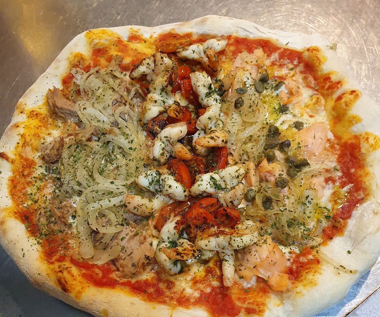 Pizza trio mare: sauce tomate, mozzarella
thon italien, oignon, saumon, câpres, 8 scampi