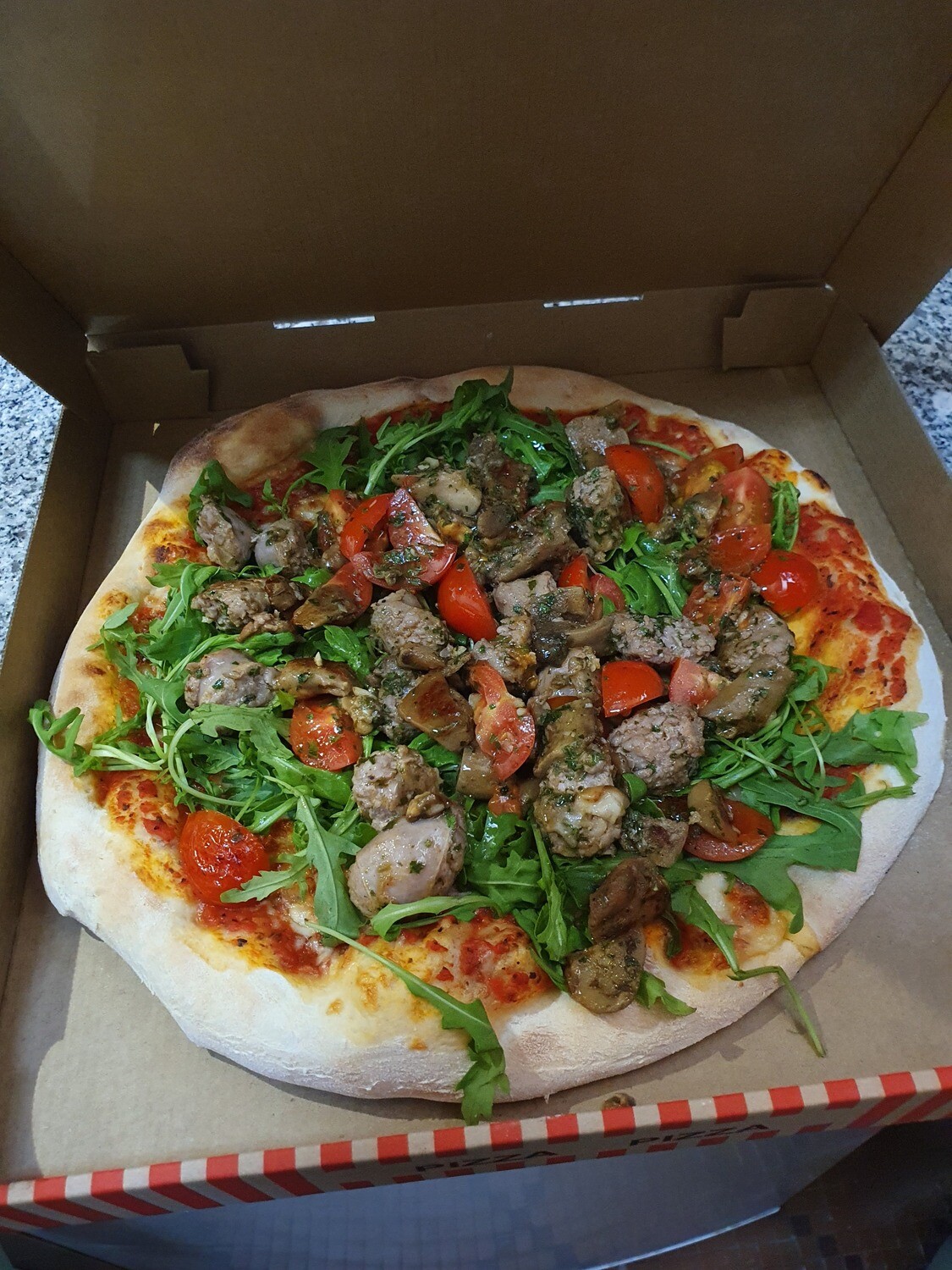Pizza Socco: sauce tomate, mozzarella, salsiccia, tomates cerise, ruccola, nduja