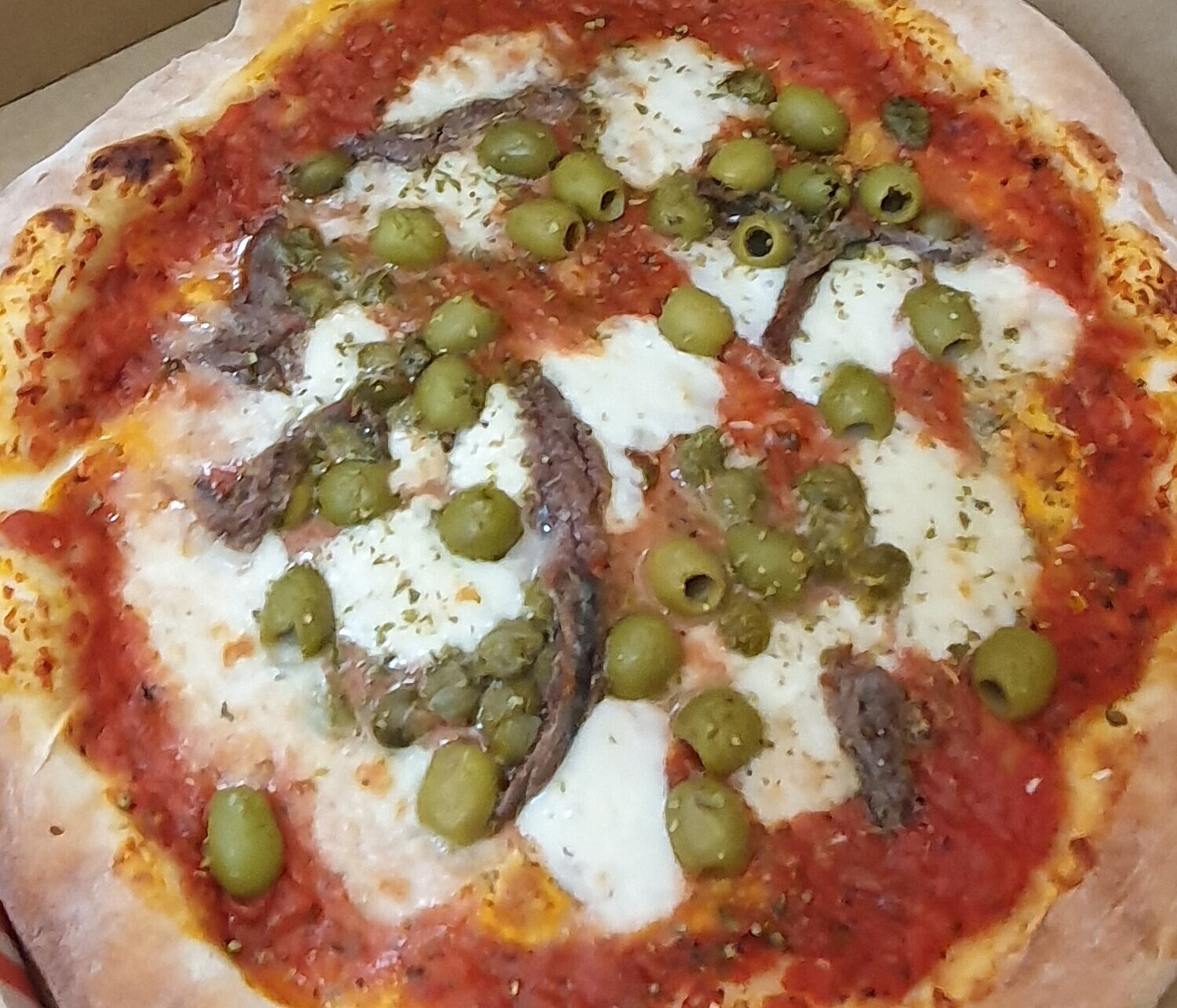 Pizza Napolitana: sauce tomate, mozzarella, câpres, anchois, olives