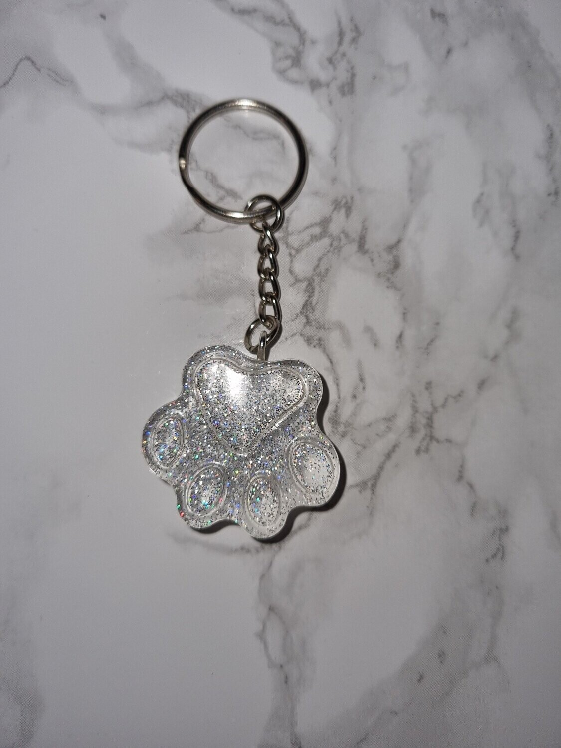Porte de clé Patte transparente à paillettes holographiques