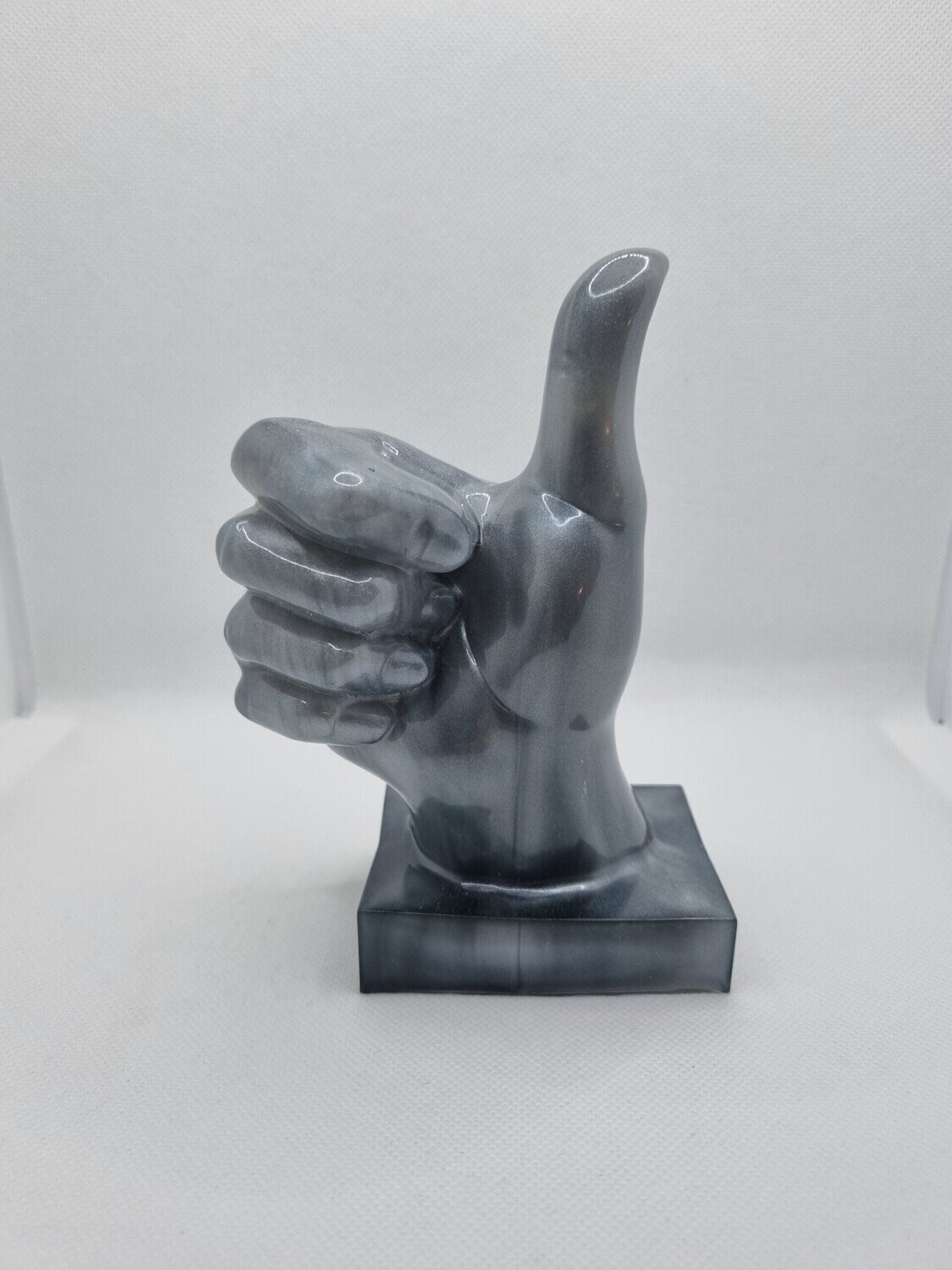 Pouce sur socle marbré gris