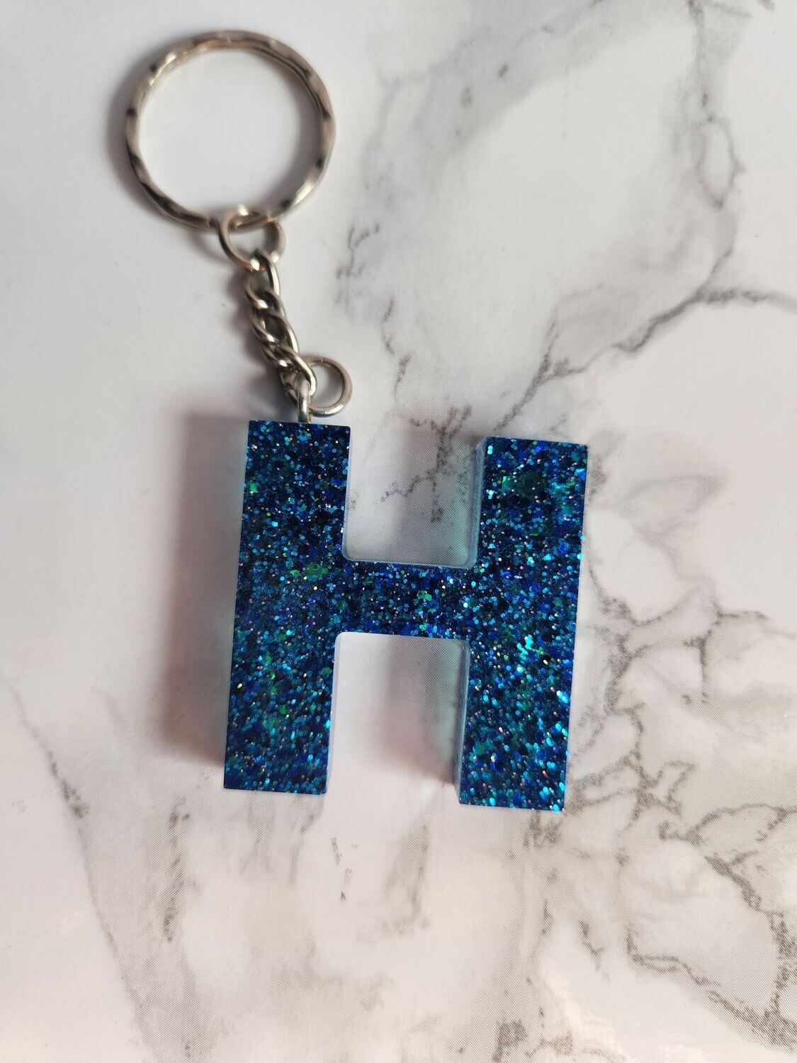 H bleu pailleté