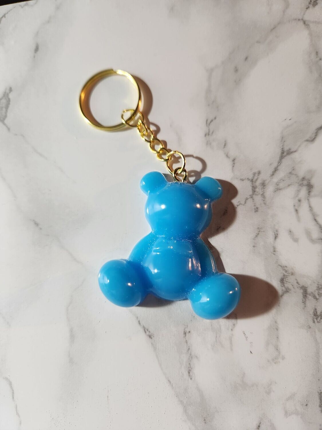 Ourson assis bleu ciel attache dorée